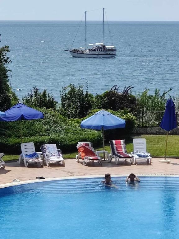a man in a swimming pool with a boat in the water at SUN AND FLOWERS APARTMENTS in front of the sea in Topola