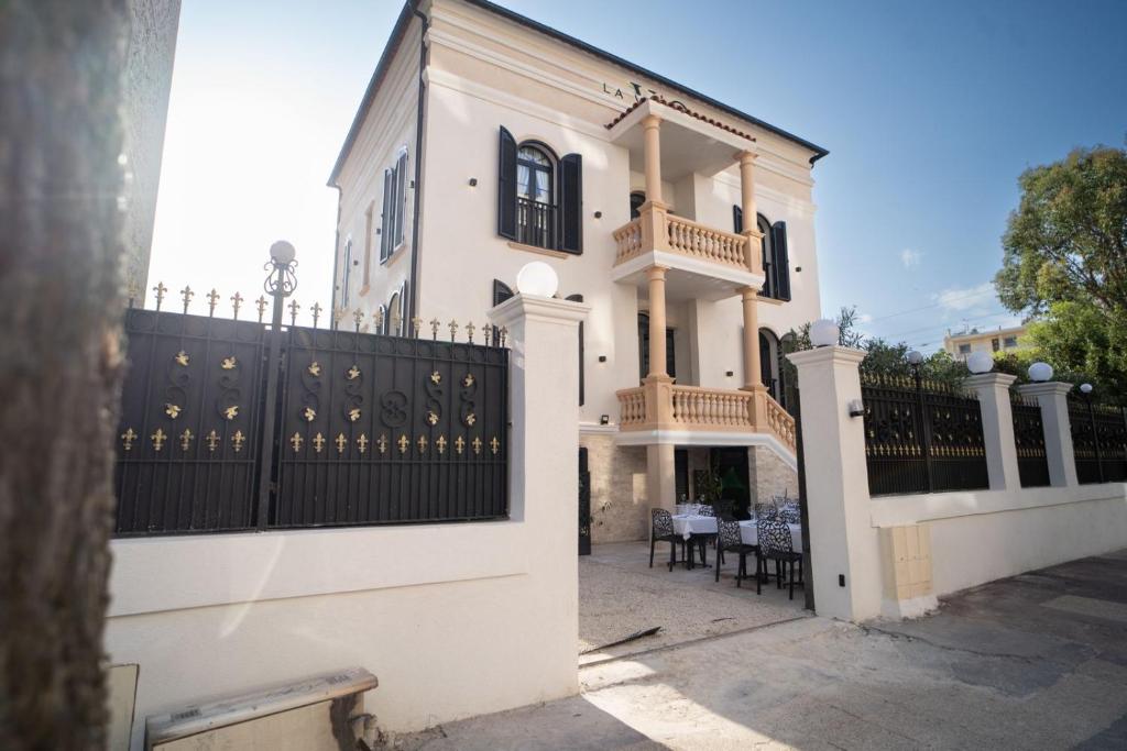 a white house with a black fence and chairs at La Villa Ora in Antibes