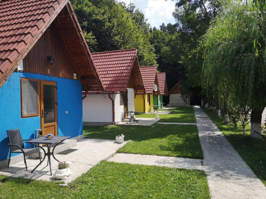 una fila di cottage con un tavolo nel cortile di Aterman's Cottages a Perşani