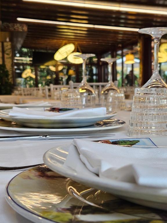 stół z białymi płytami i okularami w obiekcie Country House La Cipolla D'oro w mieście Potenza Picena