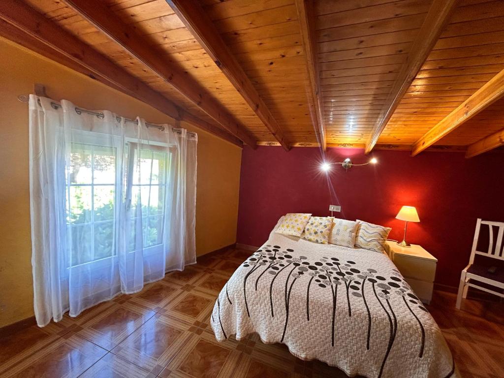 Un dormitorio con una cama y una ventana grande. en Hostal El Carro, en Laredo