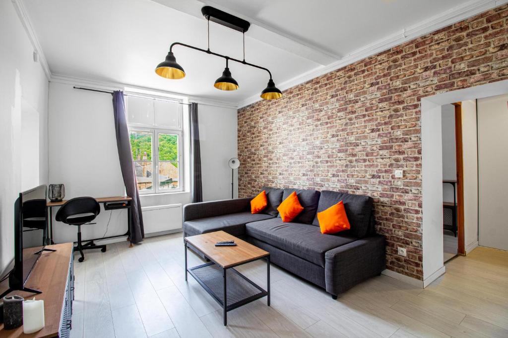 un salon avec un canapé et un mur de briques dans l'établissement Sweet-jail Proche gare, luxembourg, à Sierck-les-Bains