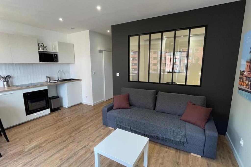 un salon avec un canapé et une table dans l'établissement Clim Ascenseur R4 T2 moderne au cœur de Toulouse, à Toulouse