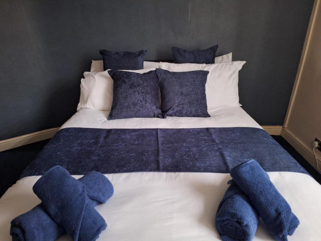 a large bed with blue stuffed animals on it at Cinematic Journeys in Nottingham