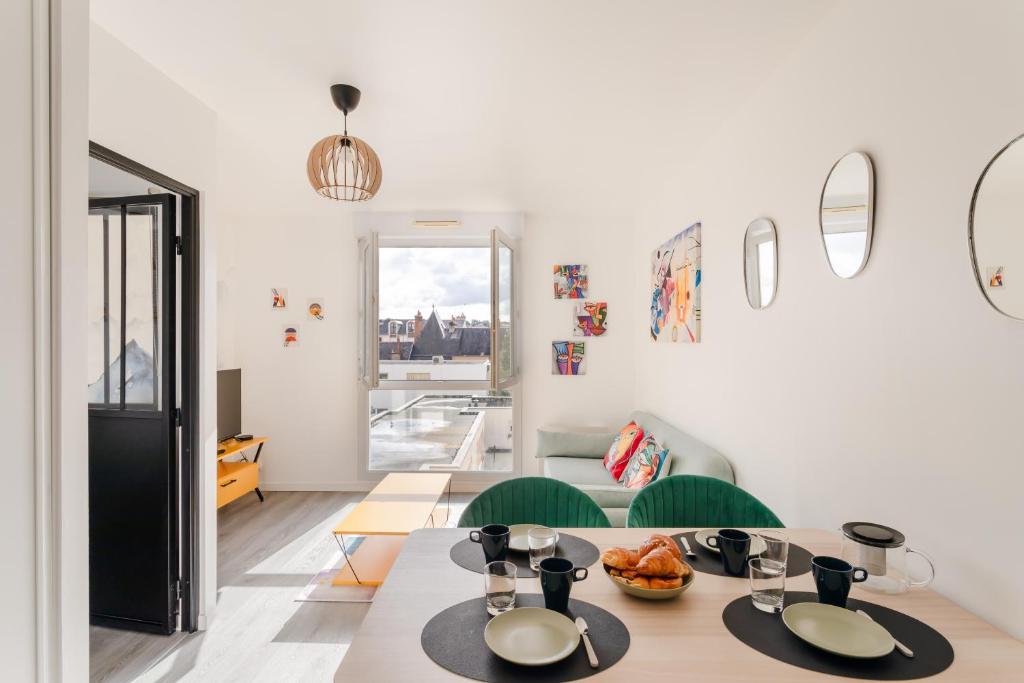 une salle à manger avec une table et des chaises vertes dans l'établissement L'Atelier - Appt 2 chambres avec parking, à Rennes