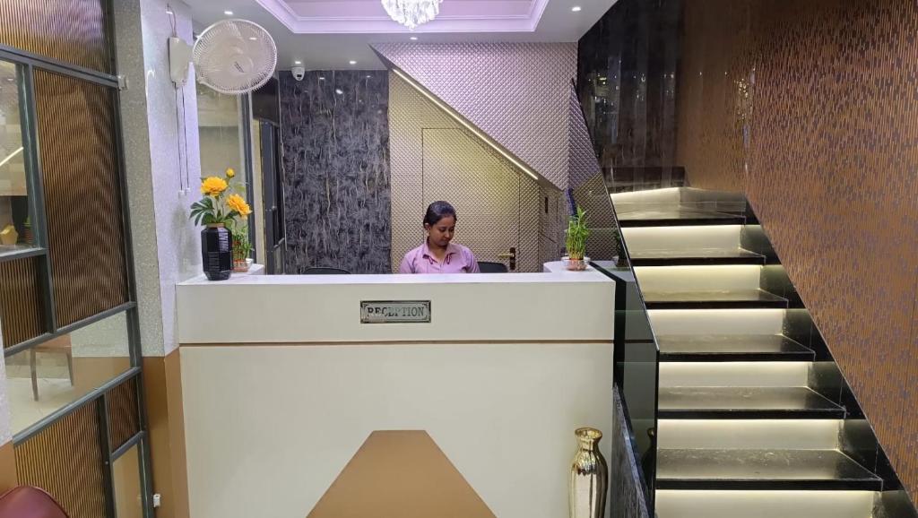 a woman sitting at a counter in a stair case at Hotel Fab International in Kolkata