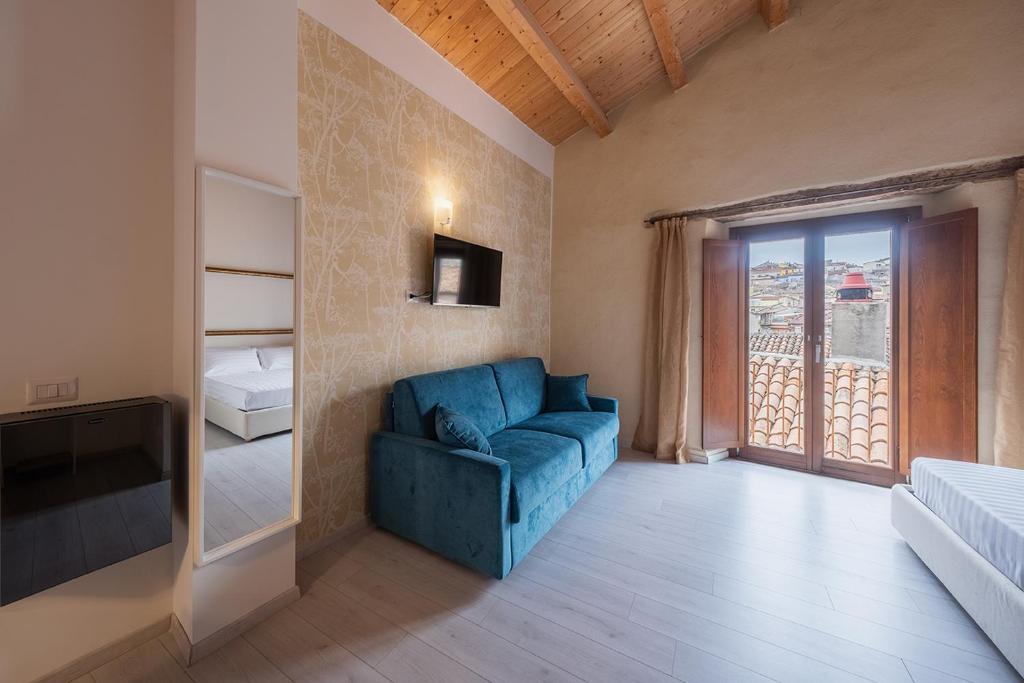 un soggiorno con divano blu e finestra di Albergo Diffuso Borgo La Terra a Riccia