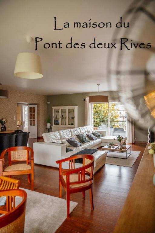 un salon avec un canapé, des tables et des chaises dans l'établissement La Maison du Pont des 2 Rives, à Guipry-Messac