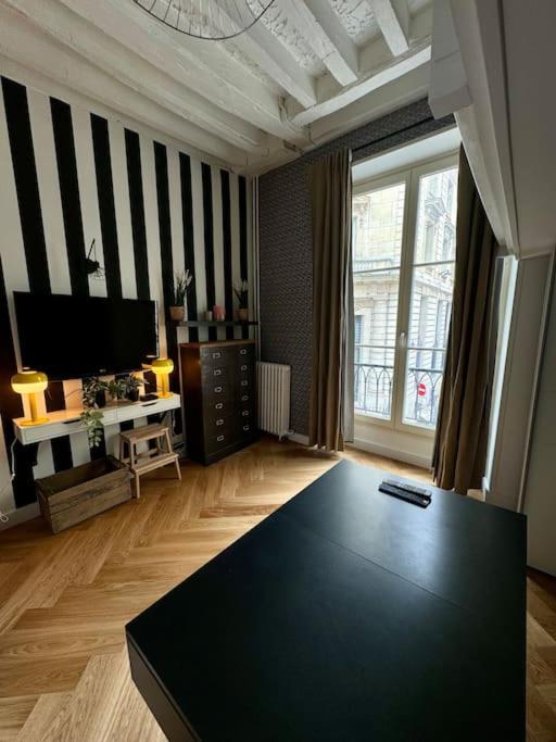 - un salon avec une table noire au milieu dans l'établissement Appartement au cœur de Paris, à Paris