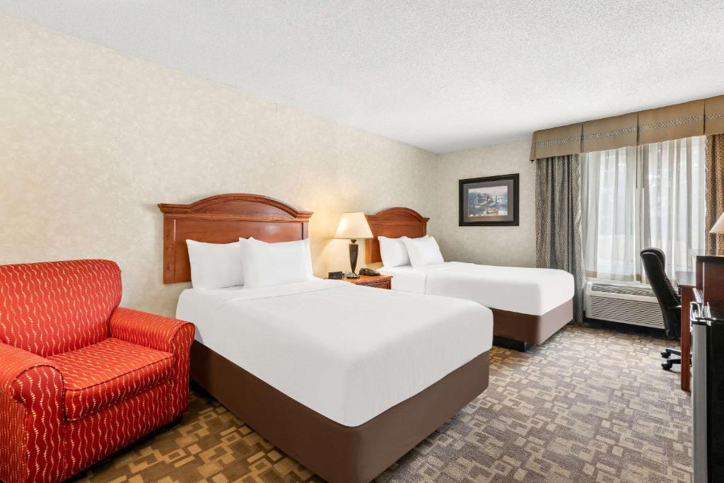 una camera d'albergo con due letti e una sedia di Quality Inn Edison-New Brunswick a Edison