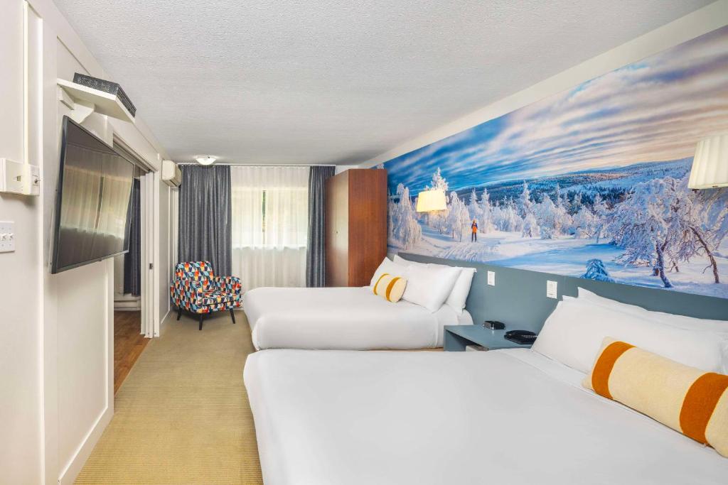 Una cama o camas en una habitación de Clarion Pointe La Malbaie