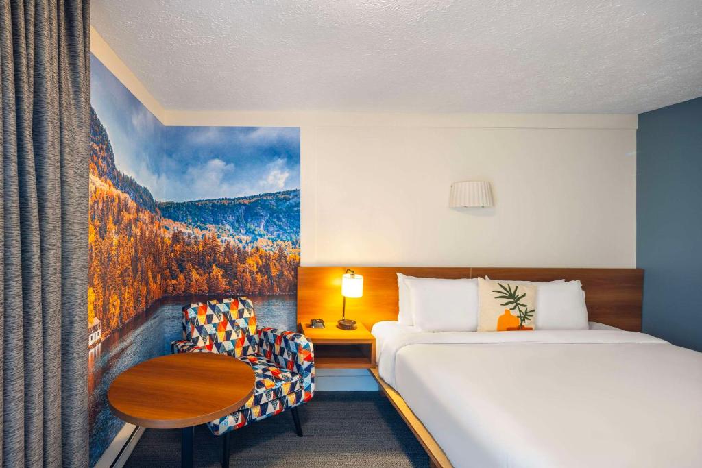 Una cama o camas en una habitación de Clarion Pointe La Malbaie