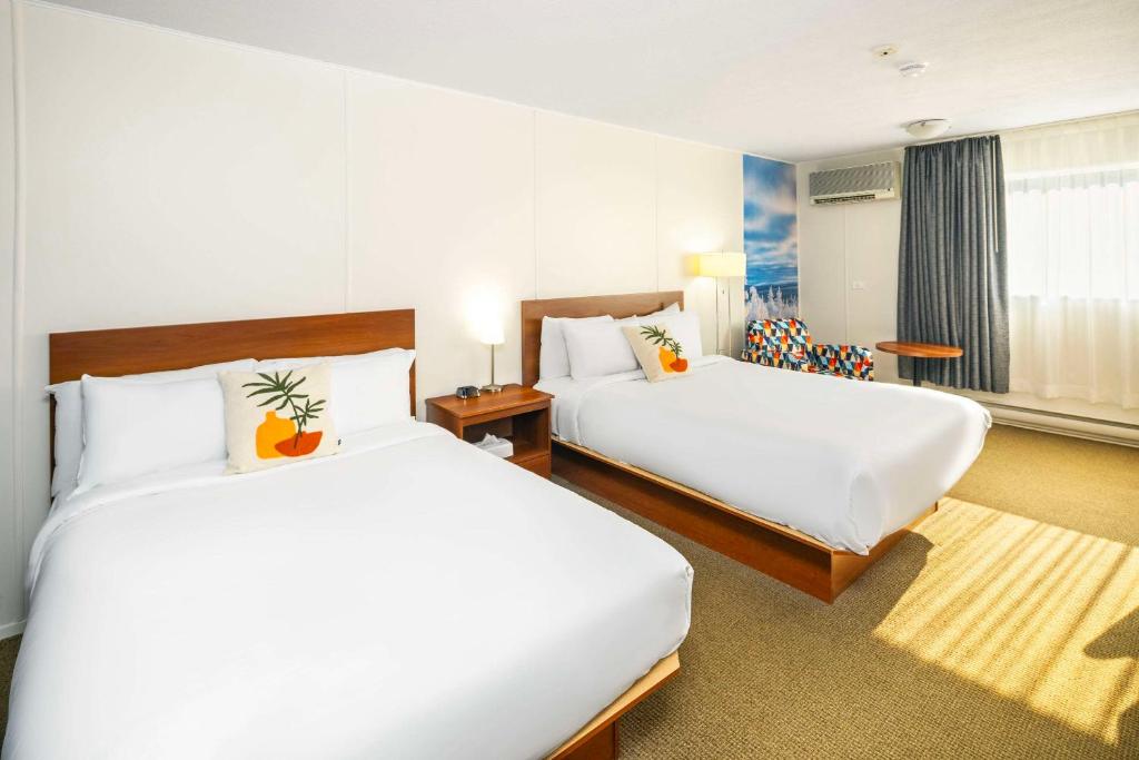 Una cama o camas en una habitación de Clarion Pointe La Malbaie