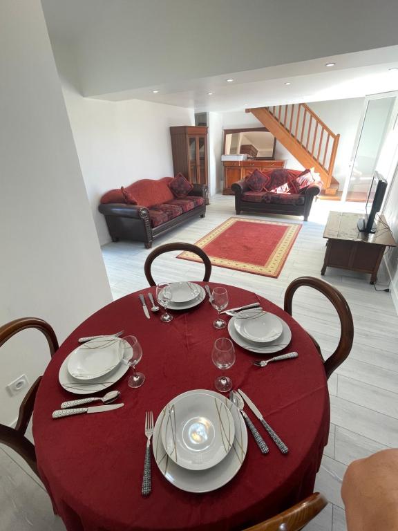 une table rouge avec plaques et argenterie dans l'établissement Maison du Paşa, à Port-la-Nouvelle