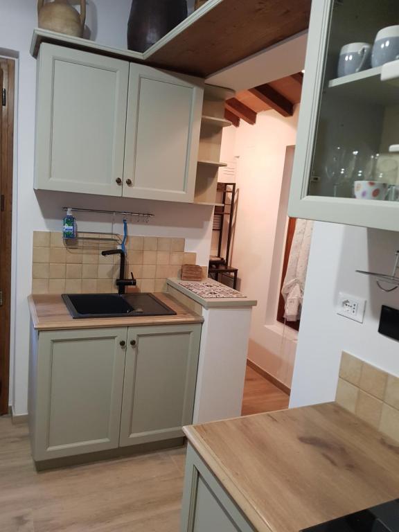 a kitchen with white cabinets and a sink at Casa il Gorellino in San Giovanni Valdarno