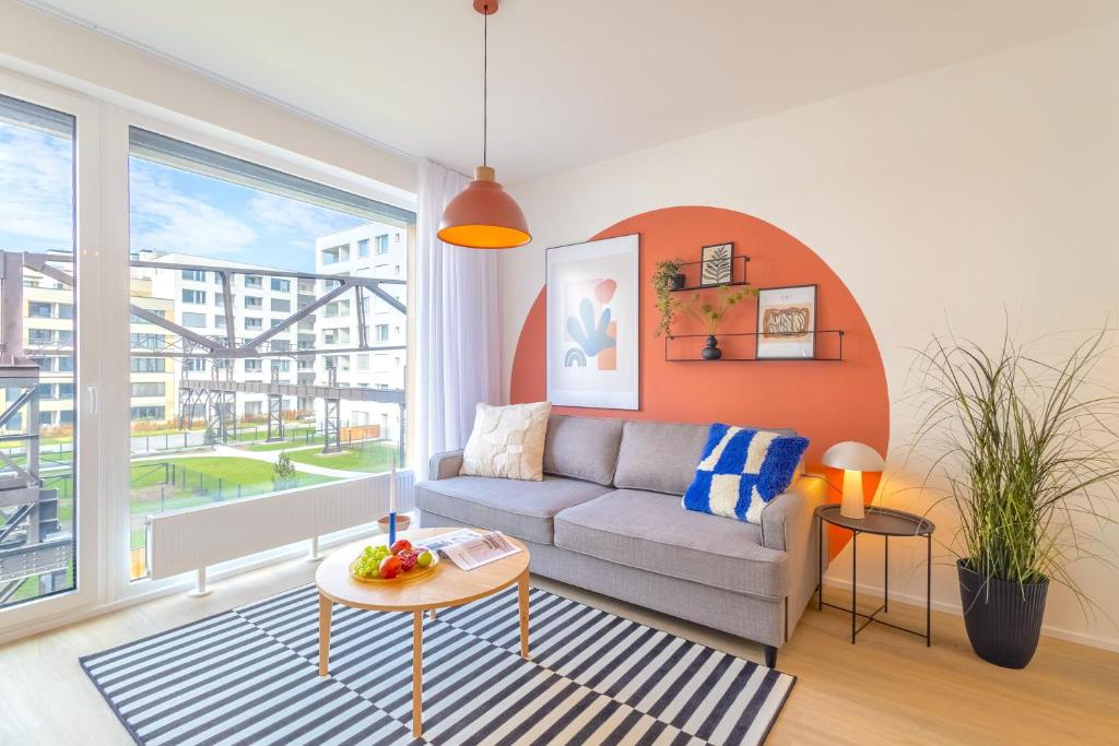 a living room with a couch and a table at Design Apartment - Balcony, Free Parking, Yoga, 10 mins to center, by Gravity Prague in Prague