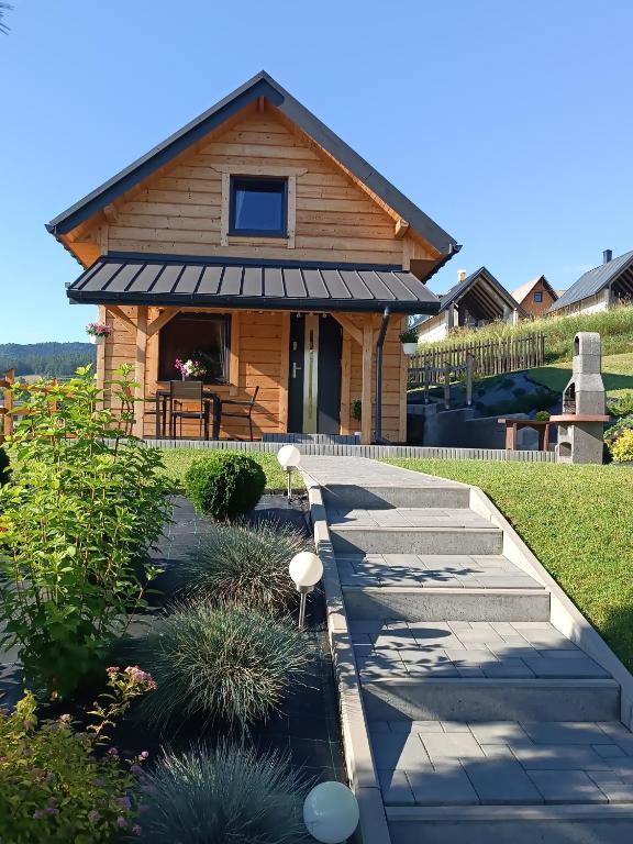 a house with a walkway in front of it at Słoneczny Domek in Kluszkowce
