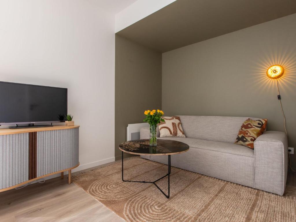 Il comprend un salon doté d'un canapé et d'une table avec une télévision. dans l'établissement Apartment Cap Océan-5 by Interhome, à Capbreton