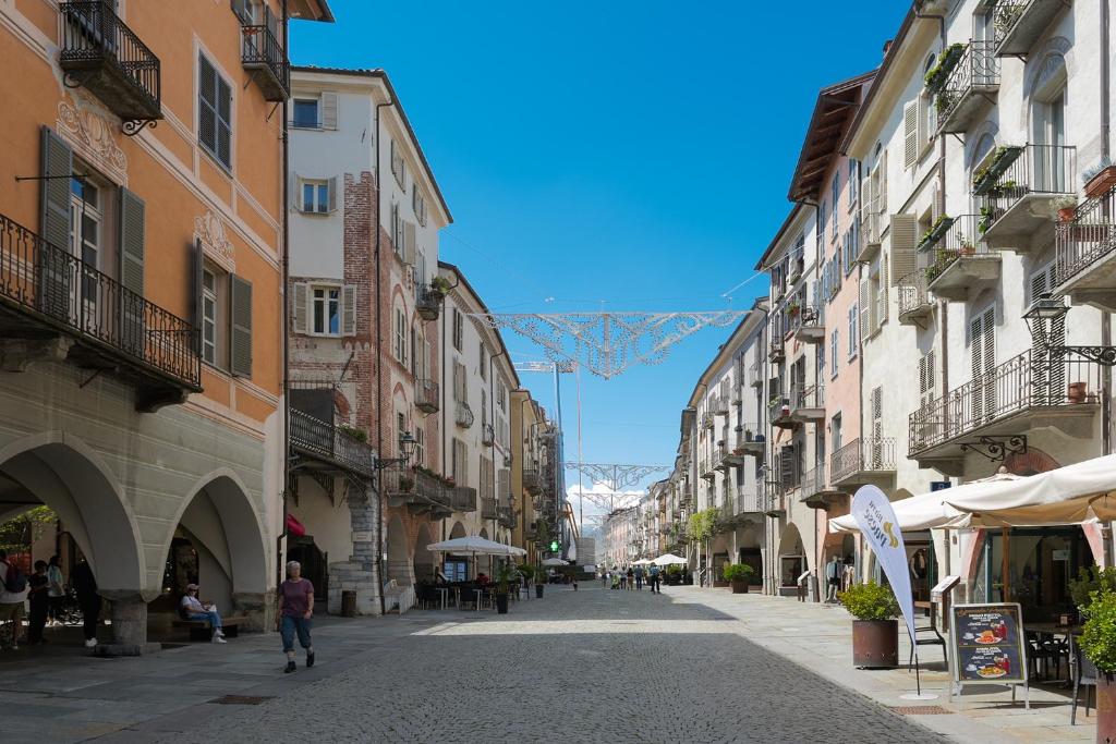 a street with buildings and a mountain in the background at Ars Nova in Cuneo
