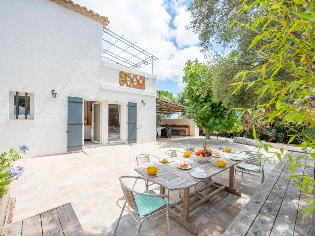 un patio extérieur avec une table et des chaises en bois dans l'établissement Apartment Villa Maeva by Interhome, à Cavalaire-sur-Mer