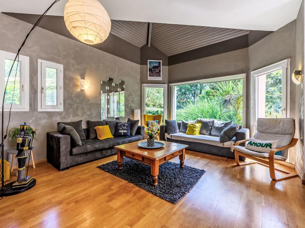 a living room with couches and a coffee table at Holiday Home Maison de Locmaria by Interhome in Ploemel