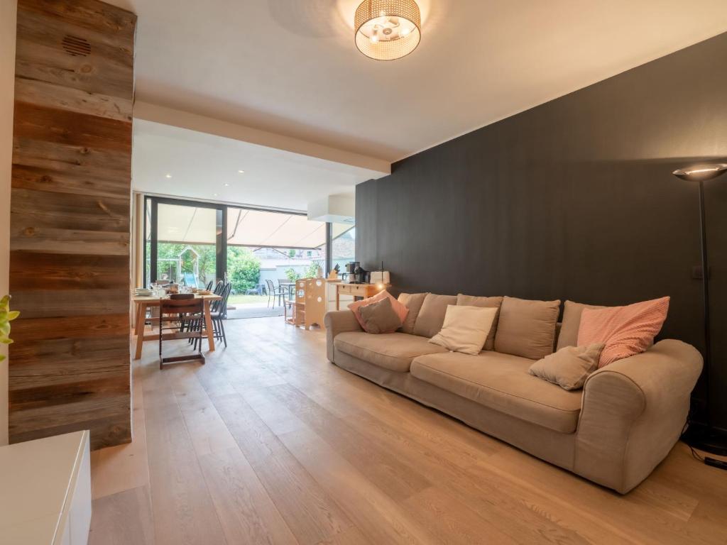 a living room with a couch and a table at Holiday Home La Gabane quiet but central house by Interhome in De Haan