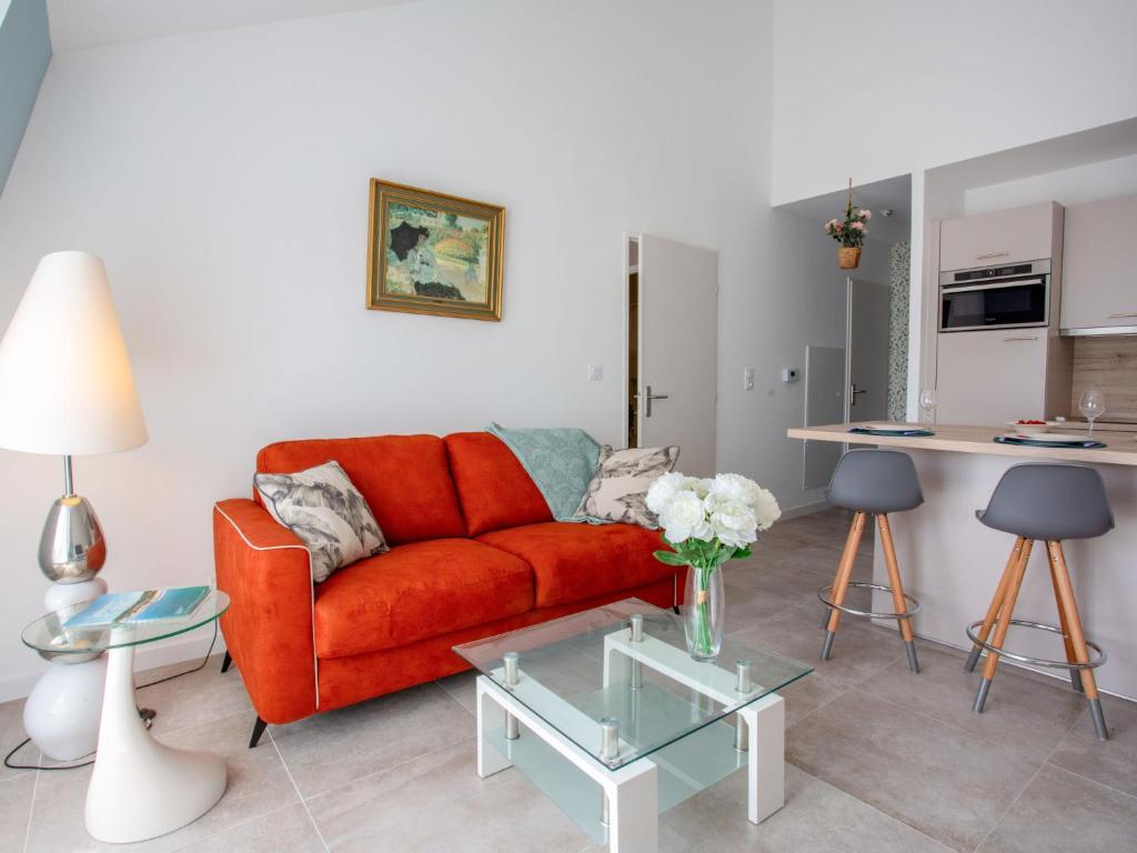 un salon avec un canapé rouge et une table dans l'établissement Apartment Côté Port by Interhome, à Pornic