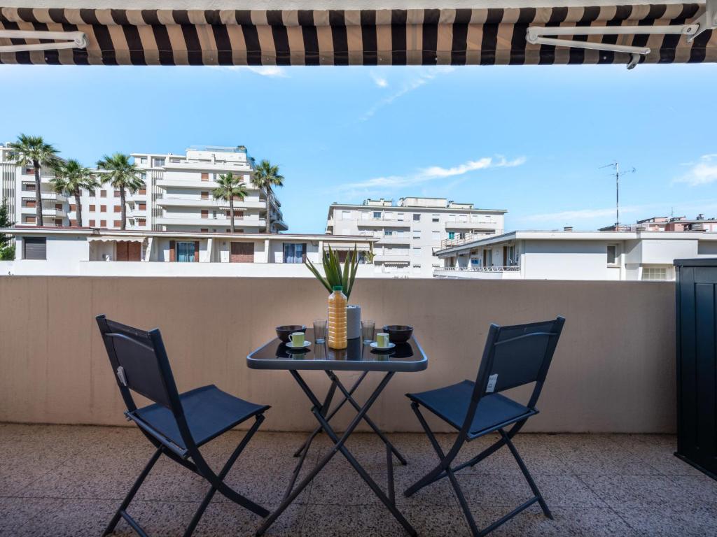 - une table et des chaises sur un balcon avec des bâtiments dans l'établissement Apartment Le Copacabana by Interhome, à Cannes