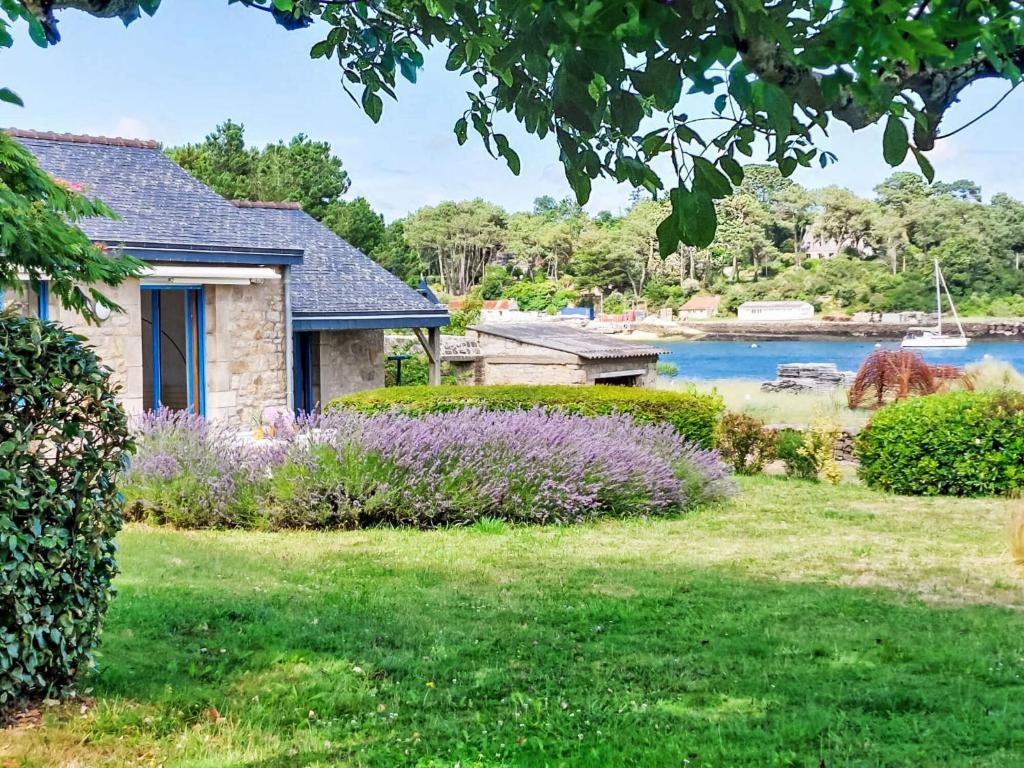 una casa con un cortile con fiori e un lago di Holiday Home La petite Pen Er Hoët by Interhome a La Trinité-sur-Mer