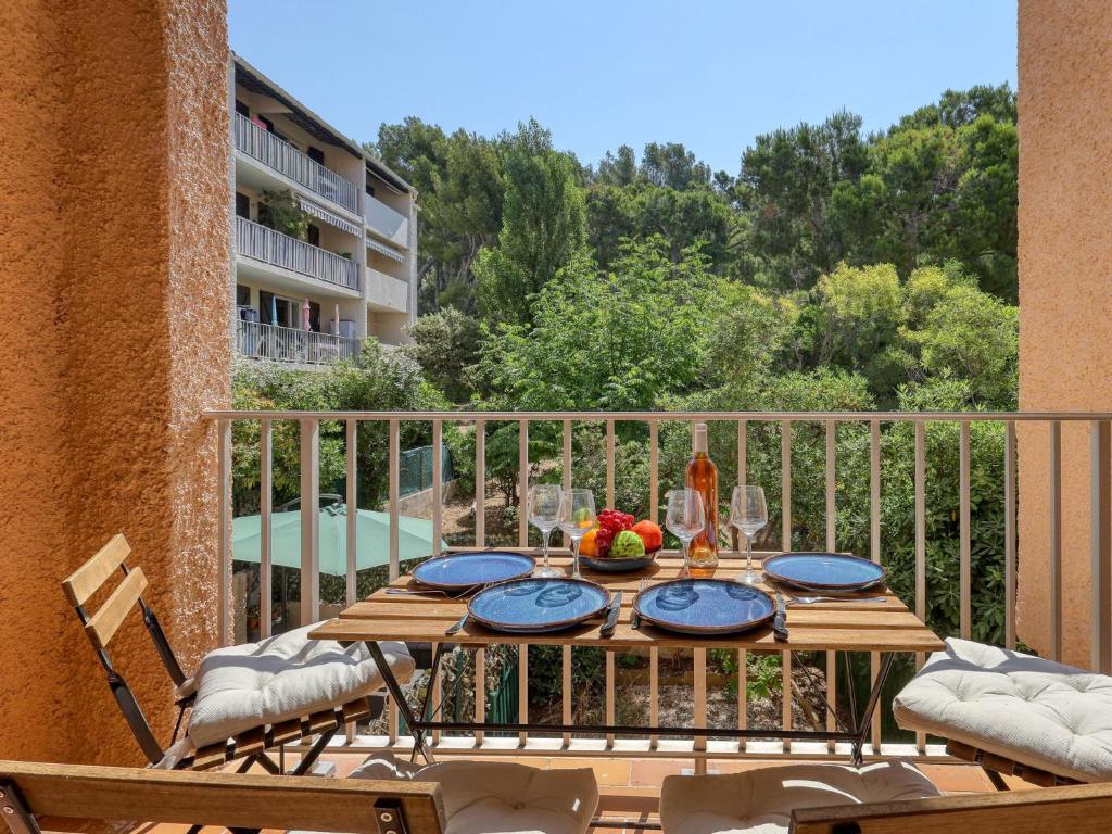 un balcon avec une table et des chaises en bois sur une terrasse dans l'établissement Studio Les Aigues Marines-72 by Interhome, à Saint-Cyr-sur-Mer