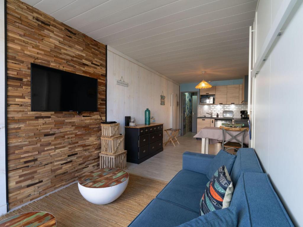 - un salon avec un canapé bleu et un mur en briques dans l'établissement Studio Port Arcachon-12 by Interhome, à Arcachon