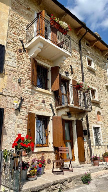a building with a balcony and flowers on it at B&B dalla Eli in Bosco Chiesanuova