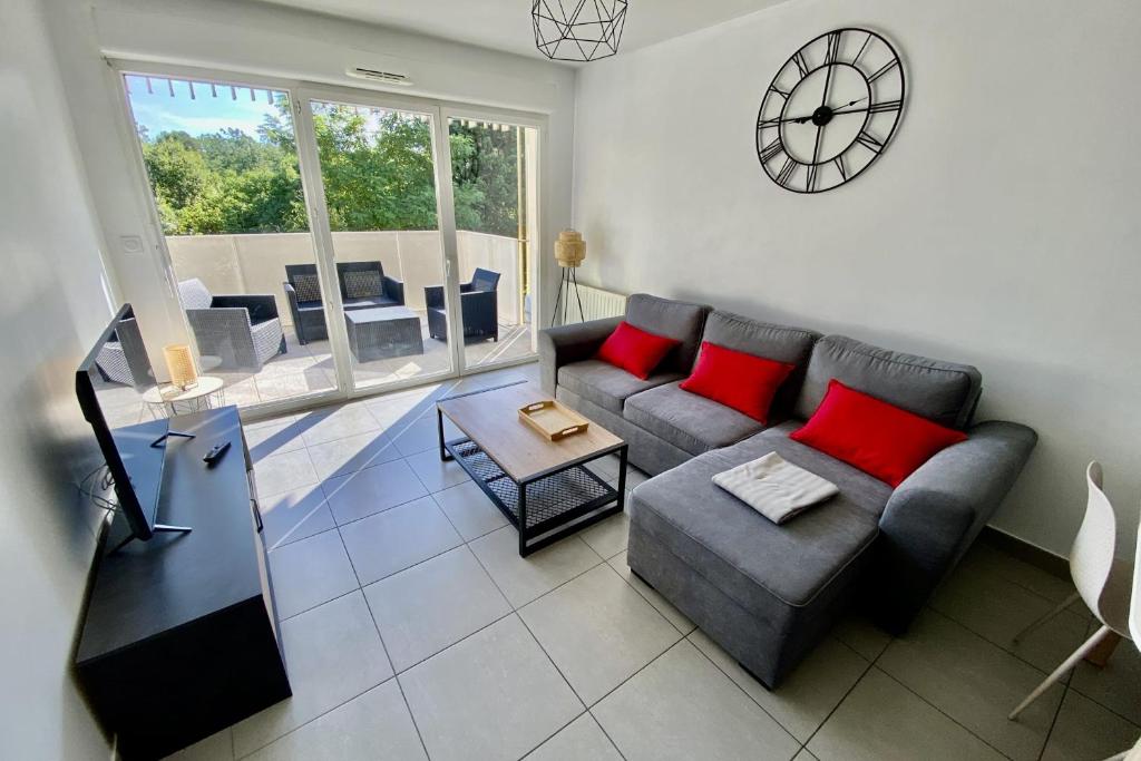 un salon avec un canapé et une horloge au mur dans l'établissement Modern T2 of 45 m in Montpellier, à Montpellier