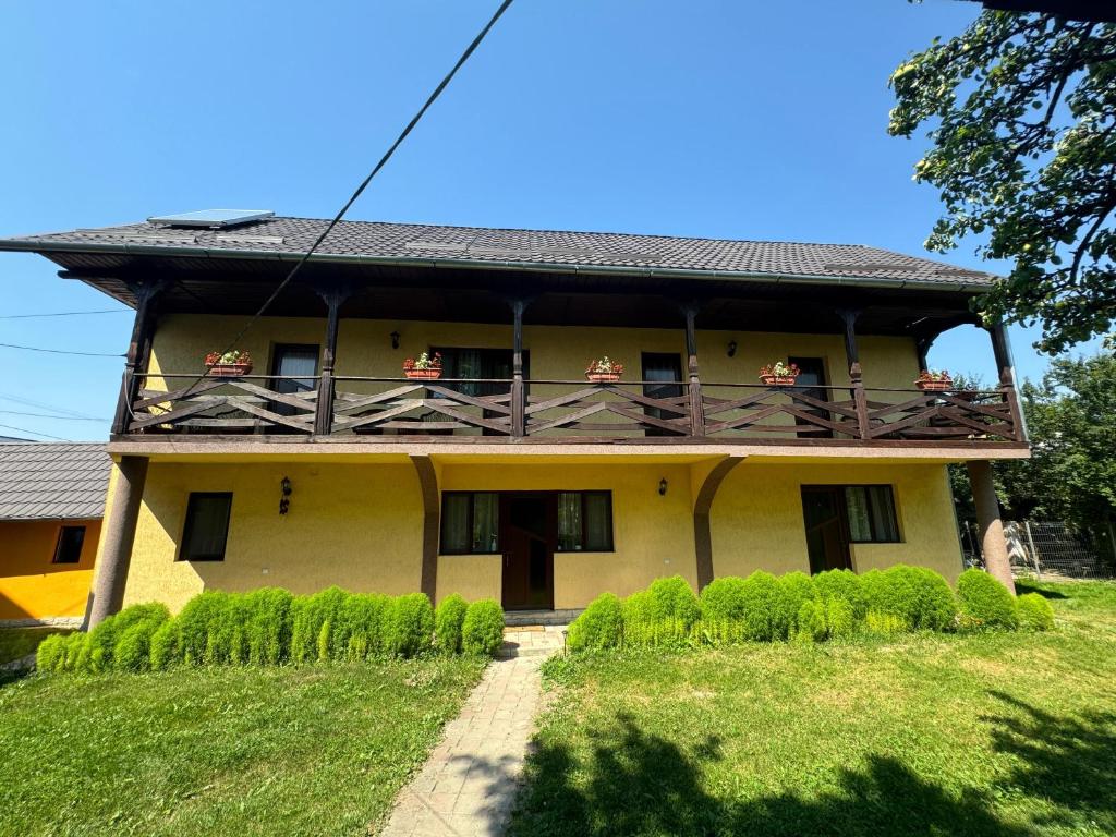 a house with a balcony with people on it at Casa Eliza in Ocna Şugatag