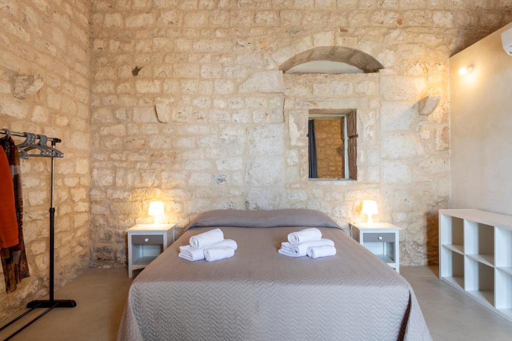 a bedroom with a bed in a stone wall at Case Mediterranee in Modica