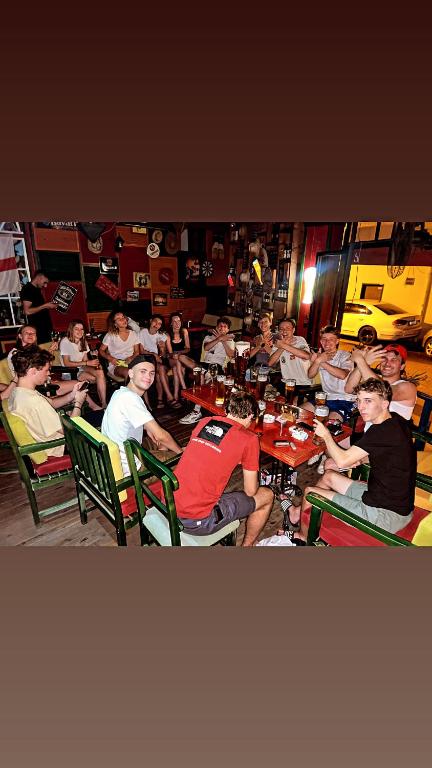 un gruppo di persone seduti ai tavoli in un ristorante di Hostel Chilli a Tirana