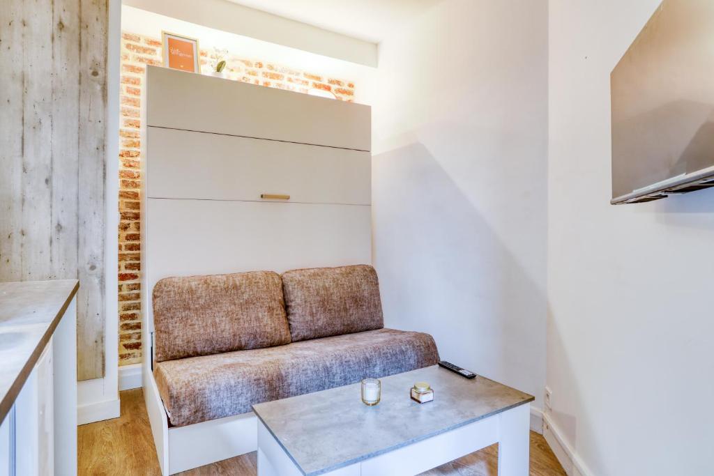 un salon avec un canapé et une table dans l'établissement Le studio Duret II, à Paris