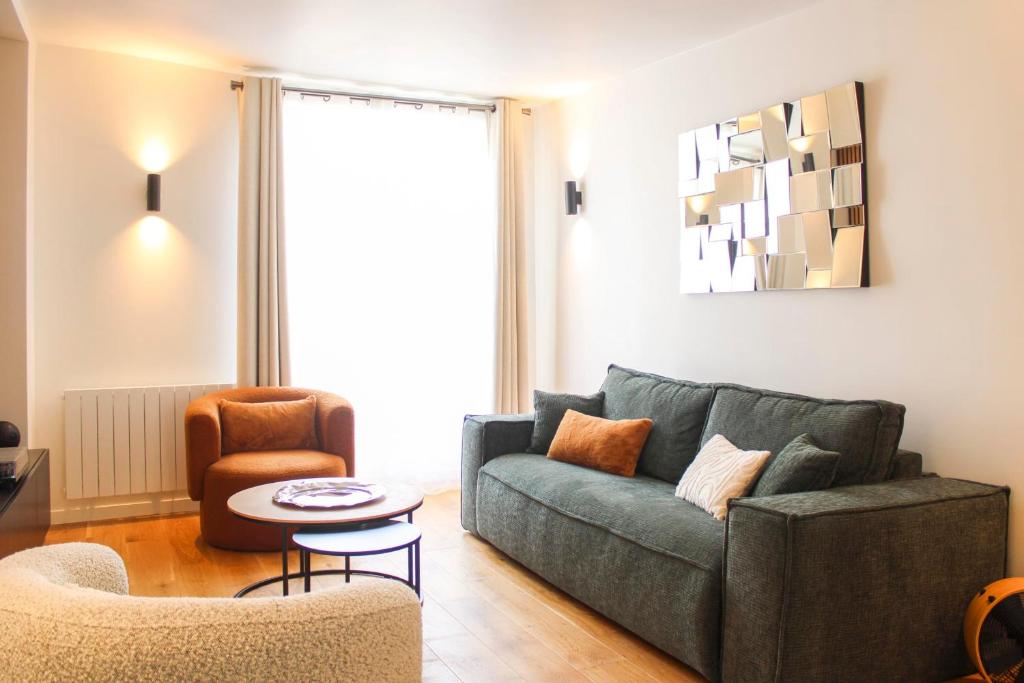 un salon avec un canapé et une chaise dans l'établissement Charming T3 in the center of Paris, à Paris