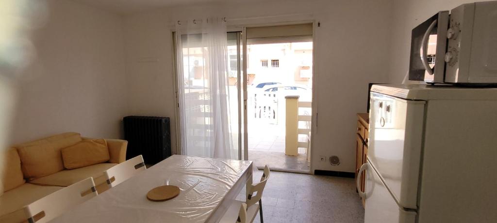 Il comprend une cuisine équipée d'une table blanche et d'un réfrigérateur. dans l'établissement Superb T2 near the beach of Port-la-Nouvelle, à Port-la-Nouvelle