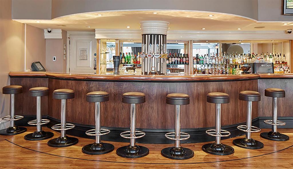 eine Bar mit einer Sitzreihe davor in der Unterkunft Lancaster Gate Hotel in London