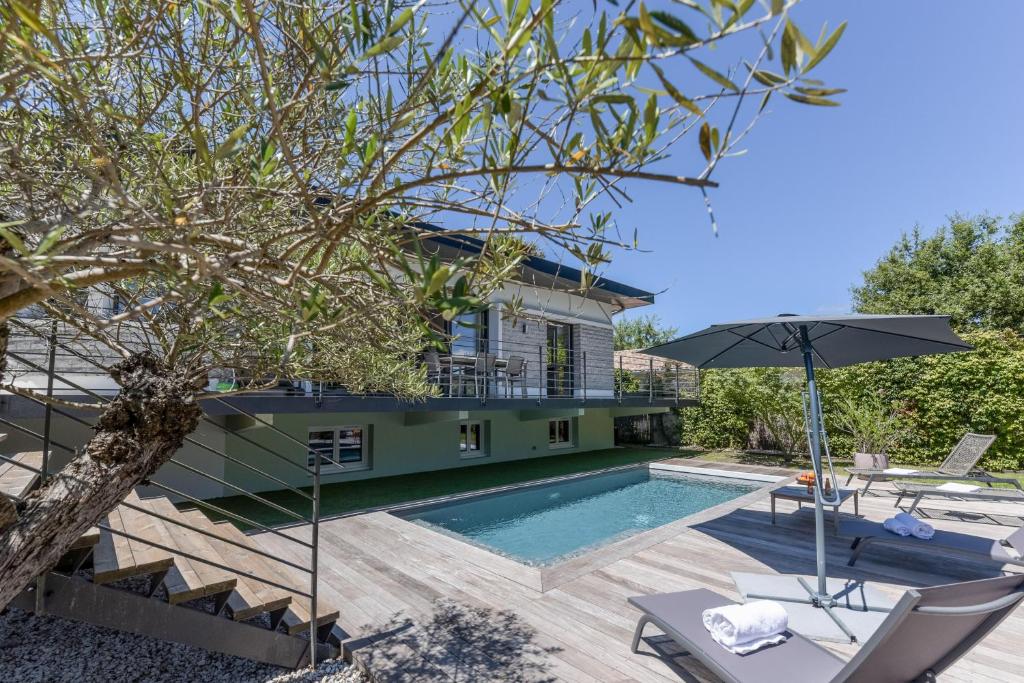 une maison avec une piscine et une maison dans l'établissement Villa Violette - Piscine privée, à Gujan-Mestras