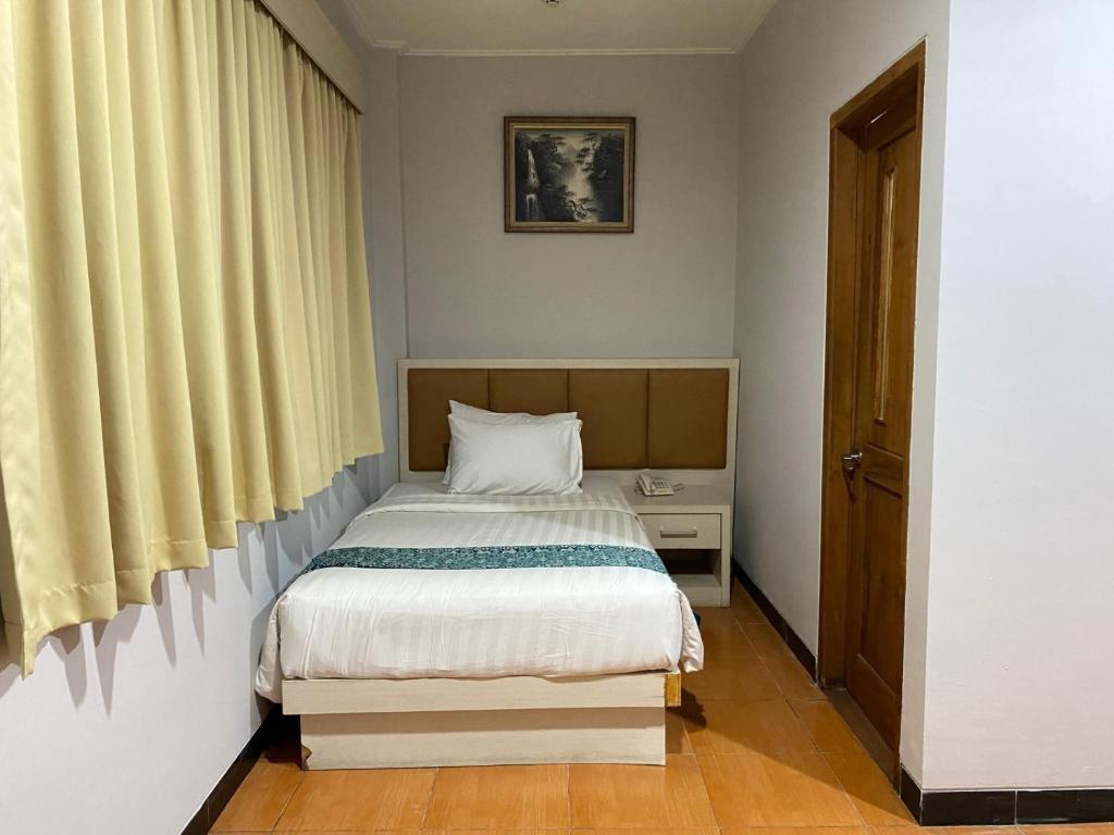 Postel nebo postele na pokoji v ubytování Front One HK Resort Simpang Lima