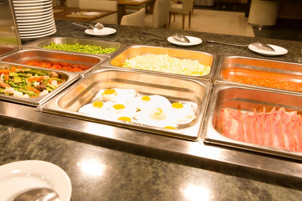 a buffet line of food with eggs and other foods at Hotel Albufera in Alfafar