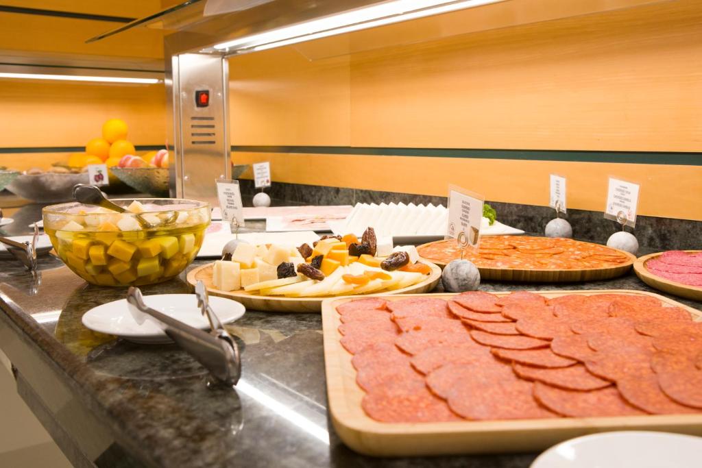 a buffet with many different types of food on a counter at Hotel Albufera in Alfafar