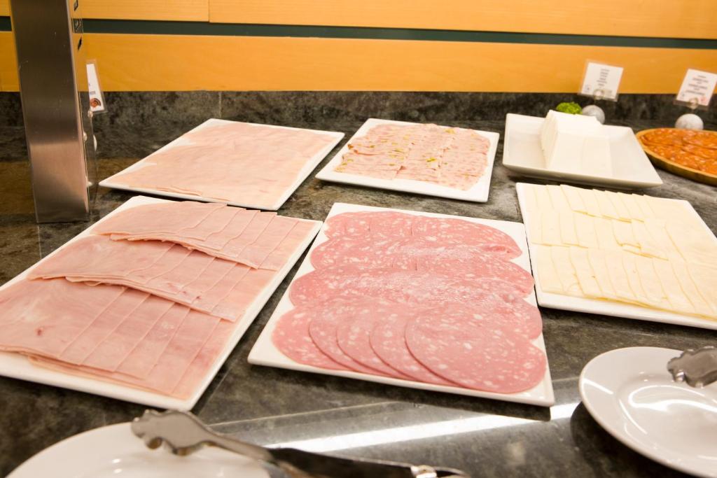 a bunch of different types of meat on a counter at Aparthotel Albufera in Alfafar