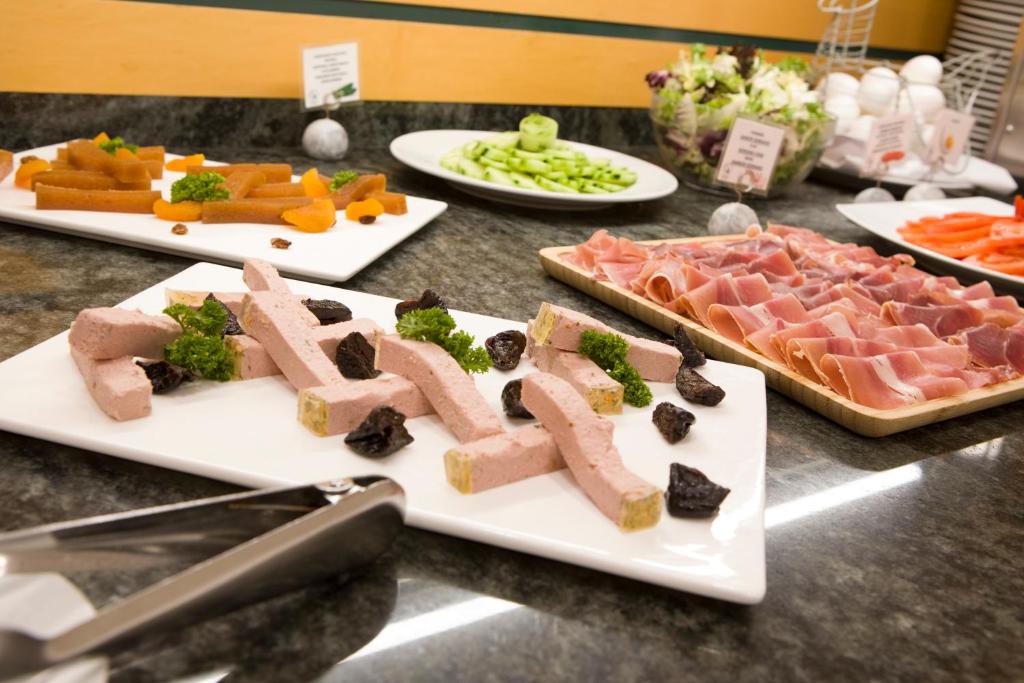 three plates with different types of food on a table at Aparthotel Albufera in Alfafar