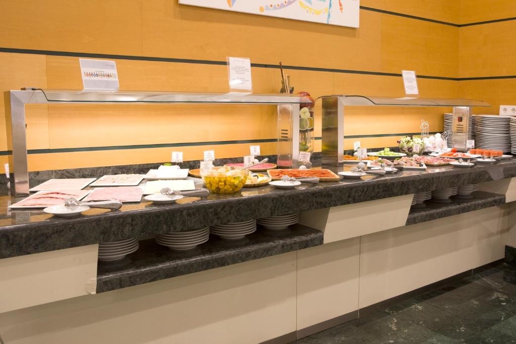 a buffet line with many plates of food at Aparthotel Albufera in Alfafar