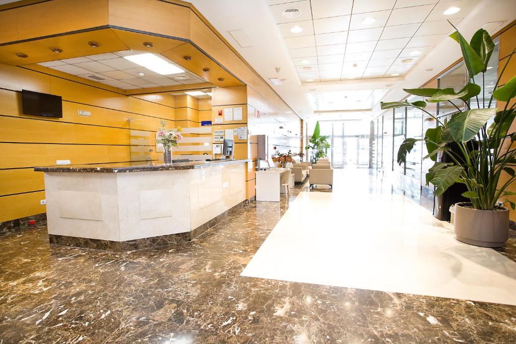 a lobby with a counter and plants in a building at Aparthotel Albufera in Alfafar