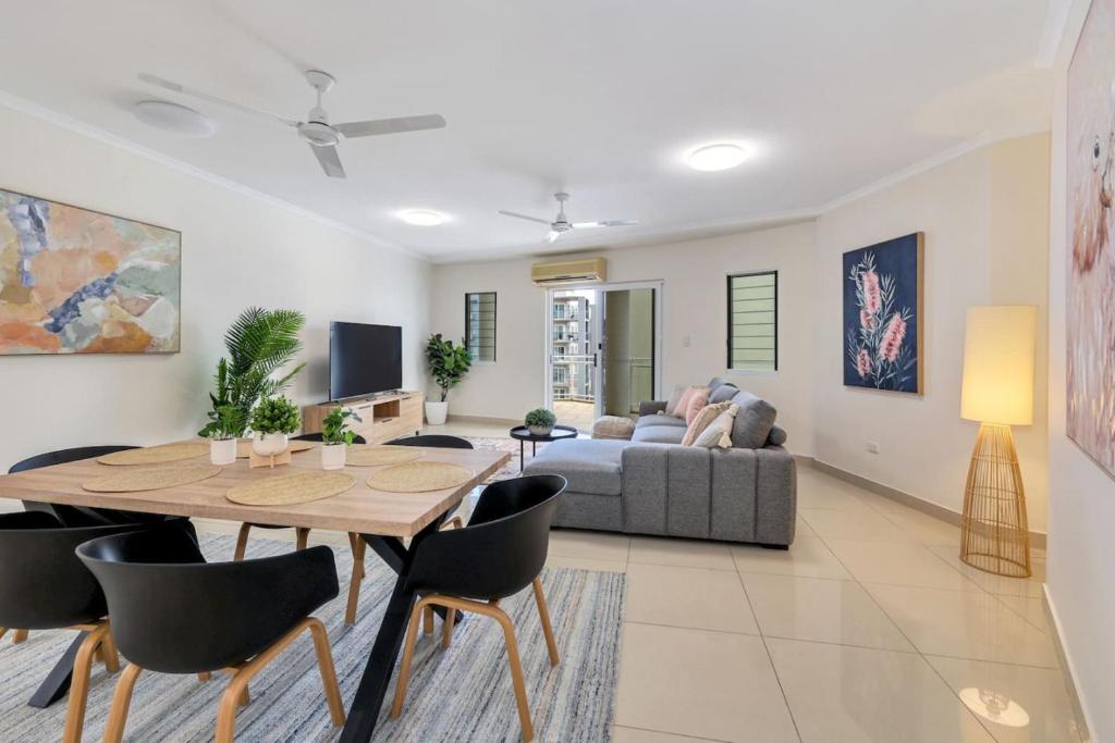una sala de estar con una mesa y un sofá en Darwin CBD stunner, en Darwin
