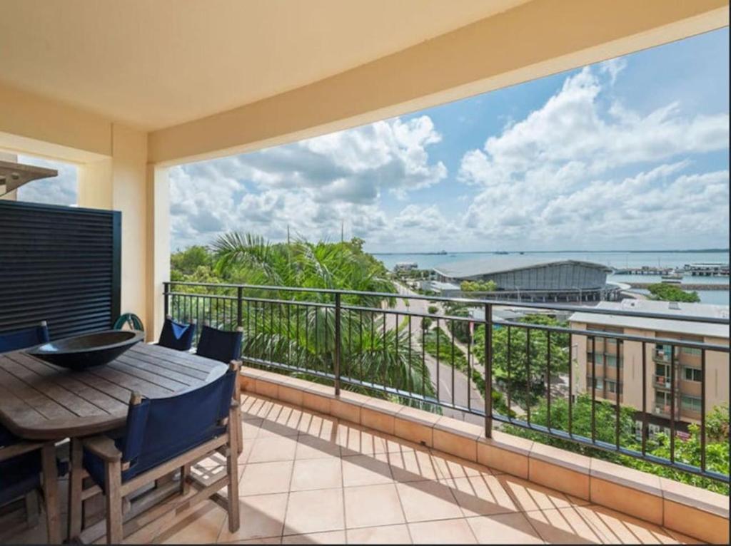 a balcony with a table and a view of the ocean at Darwin Esplanade Walk to Waterfront Wines and Waves in Darwin